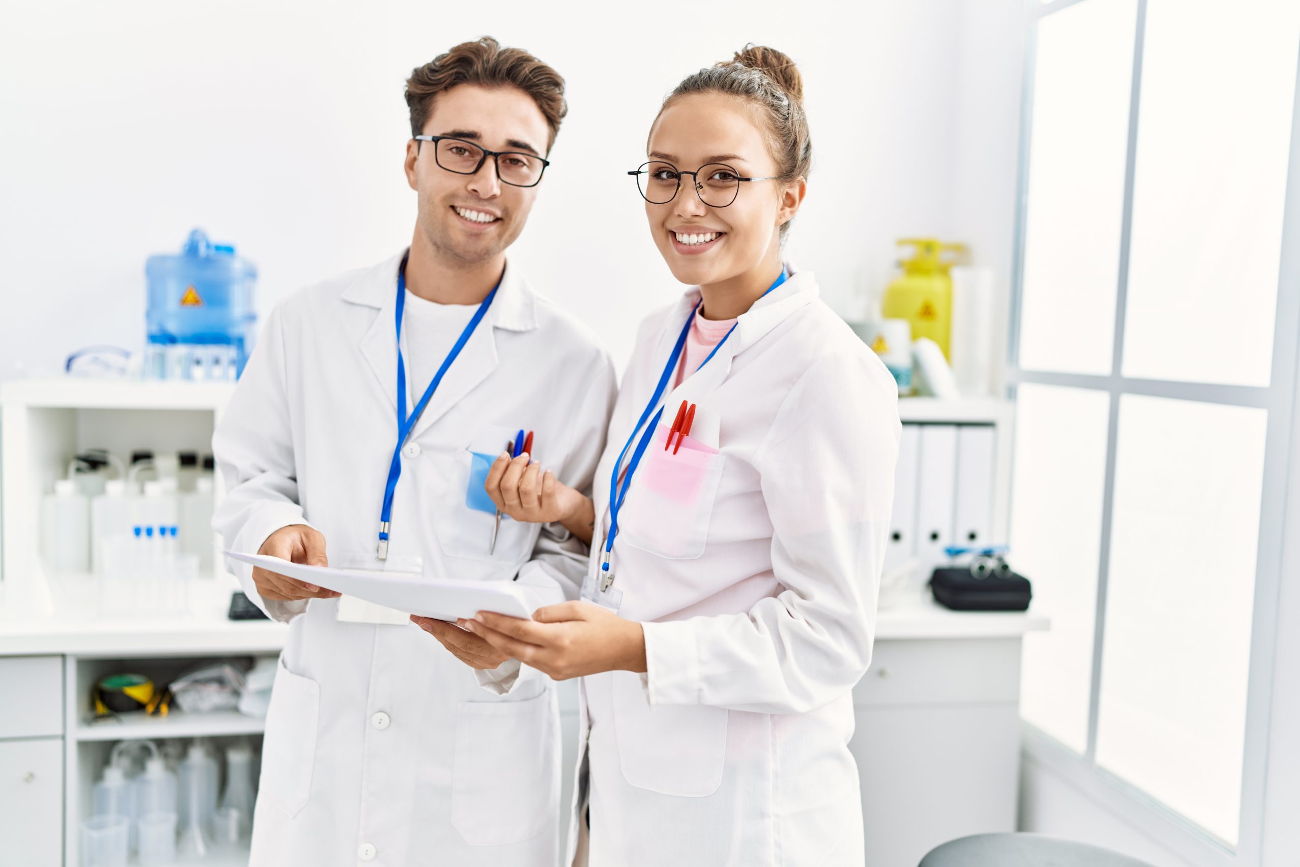 Man and woman wearing scientist uniform working at laboratory